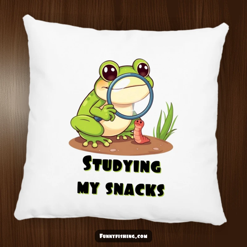 Funny frog pillow showing a cheerful frog with a magnifying glass zoomed in on a tiny, struggling worm, adding comfort and humor.