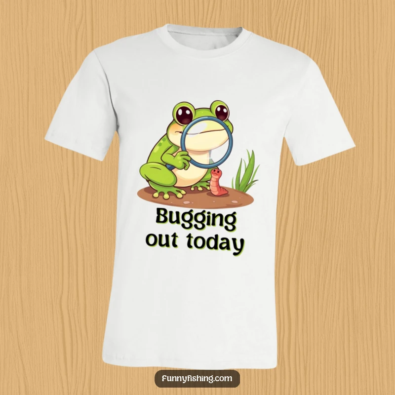 Funny frog explorer t-shirt showing a cheerful frog using a magnifying glass to zoom in on a tiny, struggling worm.